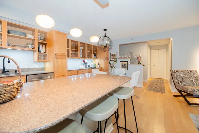 a dining room with granite countertop a table chairs and a chandelier