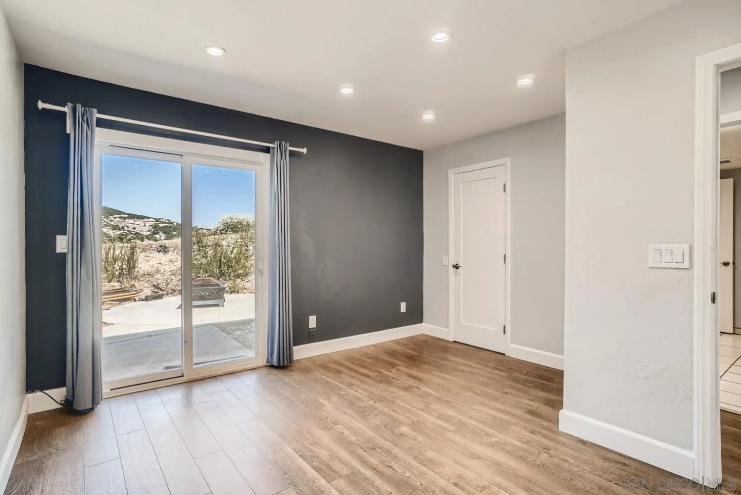 20555 Bee Valley Road Jamul, CA 91935 - Photo 23 of 33 an empty room with wooden floor and door