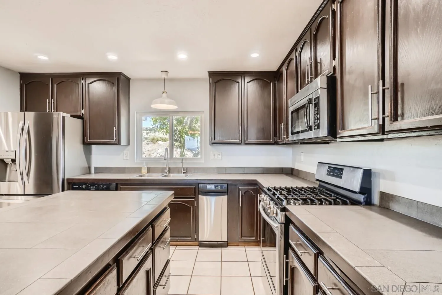 20555 Bee Valley Road Jamul, CA 91935 - Photo 6 of 33 a kitchen with stainless steel appliances granite countertop a sink a stove a microwave cabinets and a counter top space
