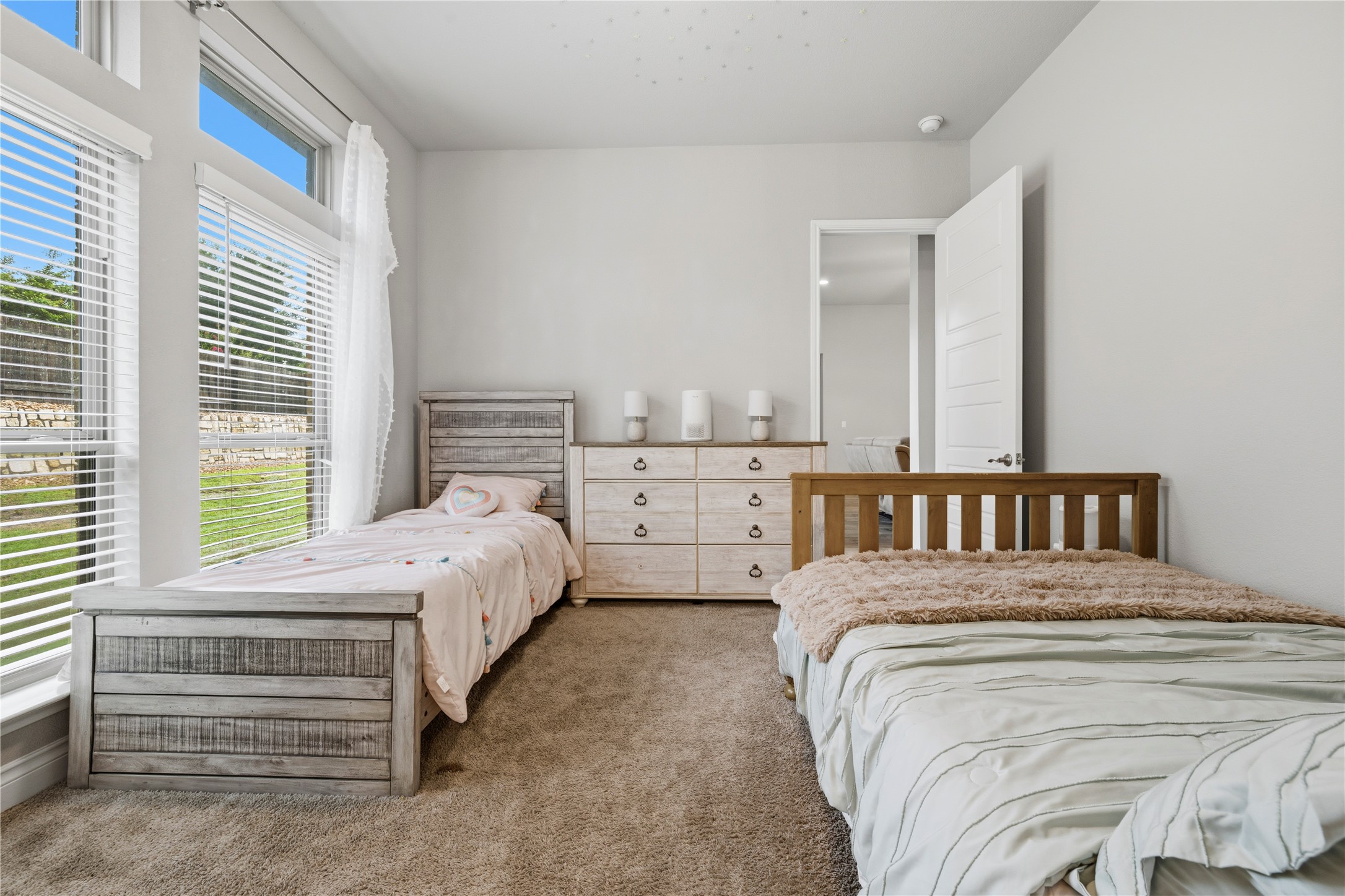 140 Catani Loop Georgetown, TX 78628 - Photo 25 of 36 Natural light floods this spacious bedroom, offering ample room and a serene retreat.