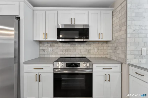 a kitchen with white cabinets and stainless steel appliances