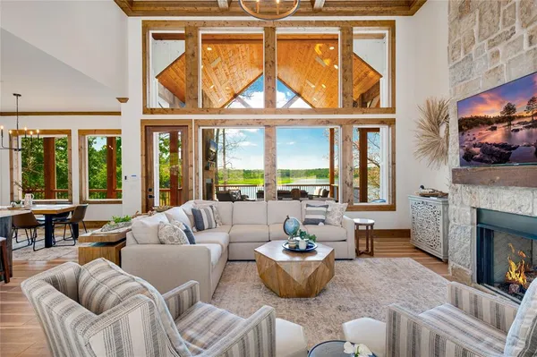 a living room with furniture a fireplace and a floor to ceiling window