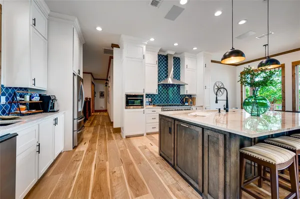 a kitchen with kitchen island a sink appliances and a counter top space