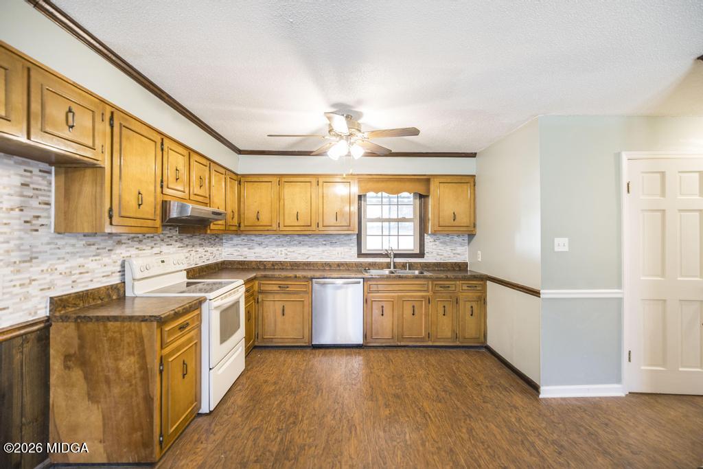 5624 Rogers Road Lizella, GA 31052 - Photo 12 of 39 a large kitchen with stainless steel appliances granite countertop a stove a sink dishwasher and a microwave oven with wooden floor