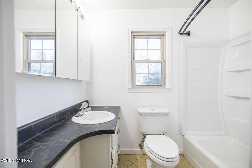 5624 Rogers Road Lizella, GA 31052 - Photo 20 of 39 a bathroom with a granite countertop sink toilet a mirror and a tub