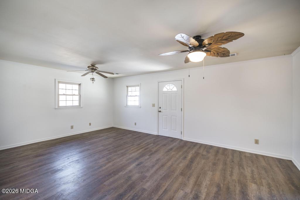 5624 Rogers Road Lizella, GA 31052 - Photo 27 of 39 an empty room with wooden floor chandelier fan and windows
