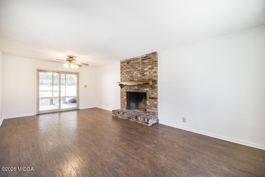 5624 Rogers Road Lizella, GA 31052 - Photo 8 of 39 an empty room with wooden floor and fireplace