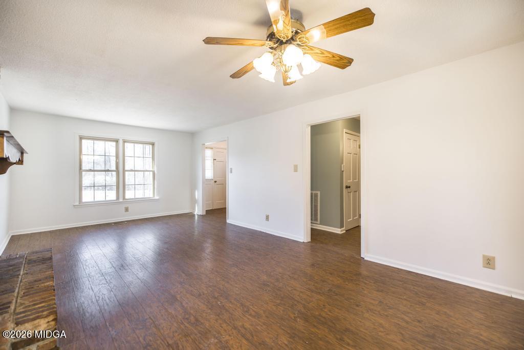 5624 Rogers Road Lizella, GA 31052 - Photo 9 of 39 an empty room with wooden floor fan and windows