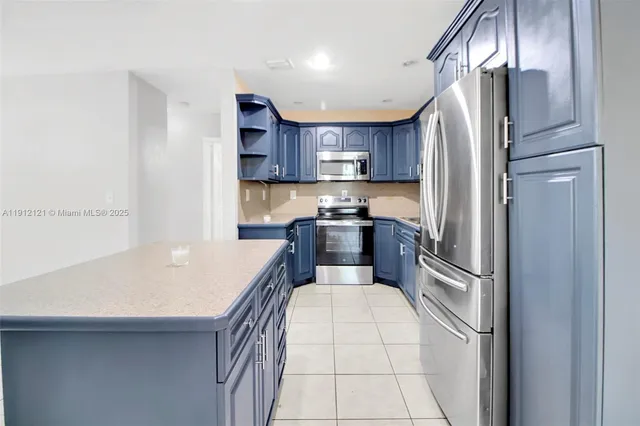 a kitchen with kitchen island a refrigerator a stove a sink and a oven