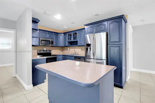 an empty room with chandelier fan and windows