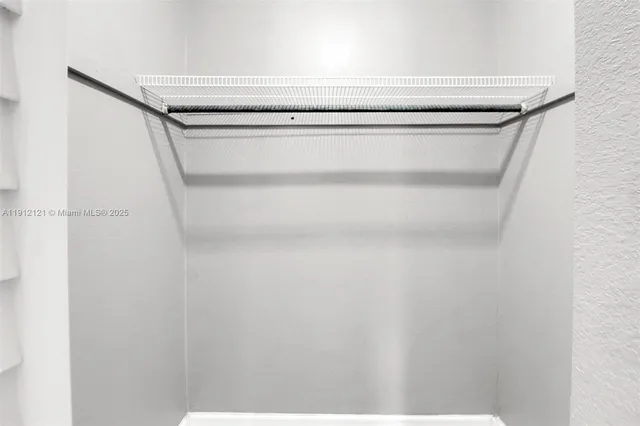 an empty room with a window and ceiling fan