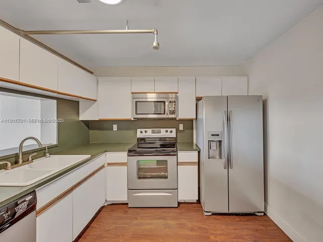a kitchen with a sink stainless steel appliances and cabinets