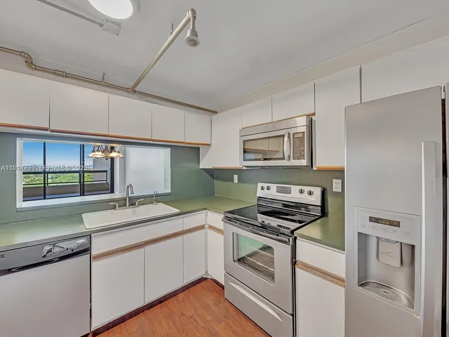 a kitchen with stainless steel appliances a stove a sink and a refrigerator