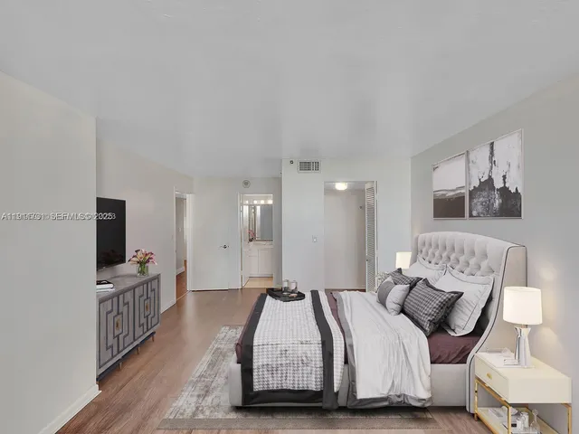 a spacious bedroom with a bed and a flat screen tv