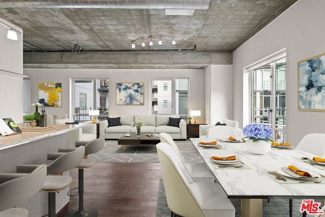 a living room with stainless steel appliances kitchen island granite countertop furniture a rug kitchen view and a chandelier