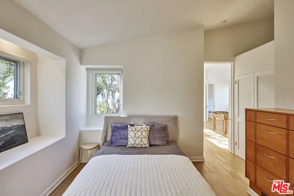a bedroom with a large bed and wooden floor