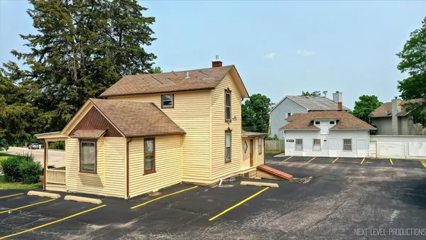a view of a house with a yard and large tree