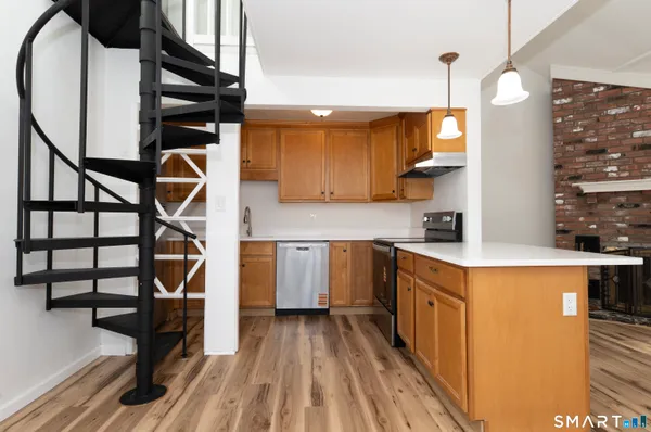 a kitchen with kitchen island a stove a sink and a refrigerator with wooden floor
