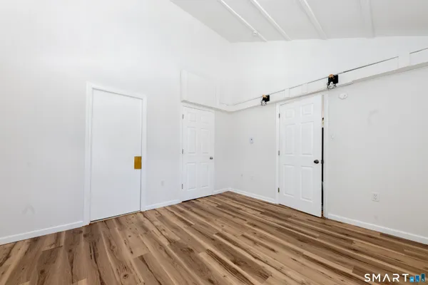 a view of a room with wooden floor and white walls