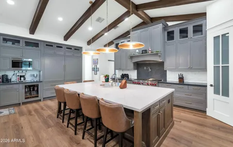 a large white kitchen with a large island in the center