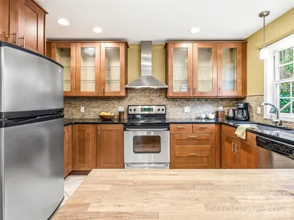 a kitchen with stainless steel appliances granite countertop a stove a sink and a microwave