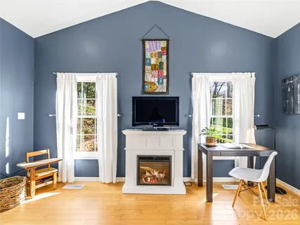 a living room with furniture a fireplace and a flat screen tv