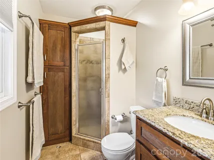 a bathroom with a granite countertop sink toilet and shower
