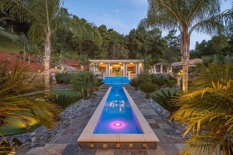 an aerial view of a house with a swimming pool and garden