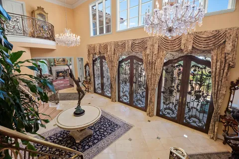 a living room with furniture a fireplace and a chandelier