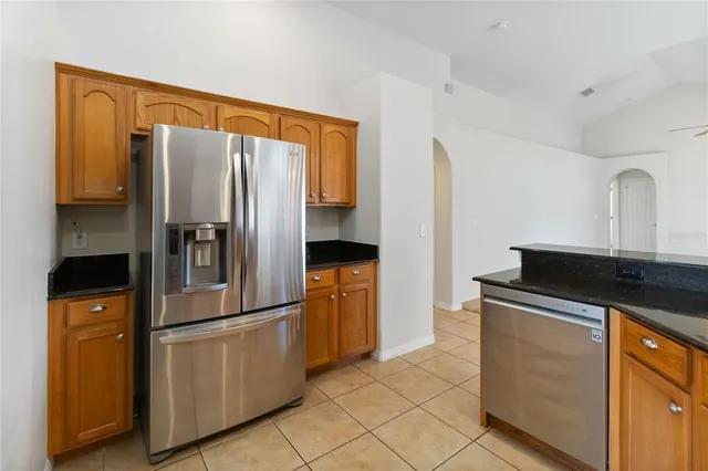 a kitchen with stainless steel appliances granite countertop a refrigerator and a stove
