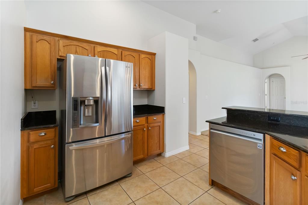 4136 Maidu Court St. Cloud, FL 34772 - Photo 11 of 40 a kitchen with stainless steel appliances granite countertop a refrigerator and a stove