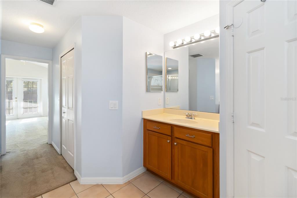 4136 Maidu Court St. Cloud, FL 34772 - Photo 21 of 40 a bathroom with a granite countertop sink a mirror and a shower