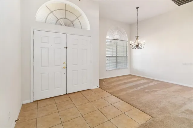 an empty room with kitchen view and wooden floor