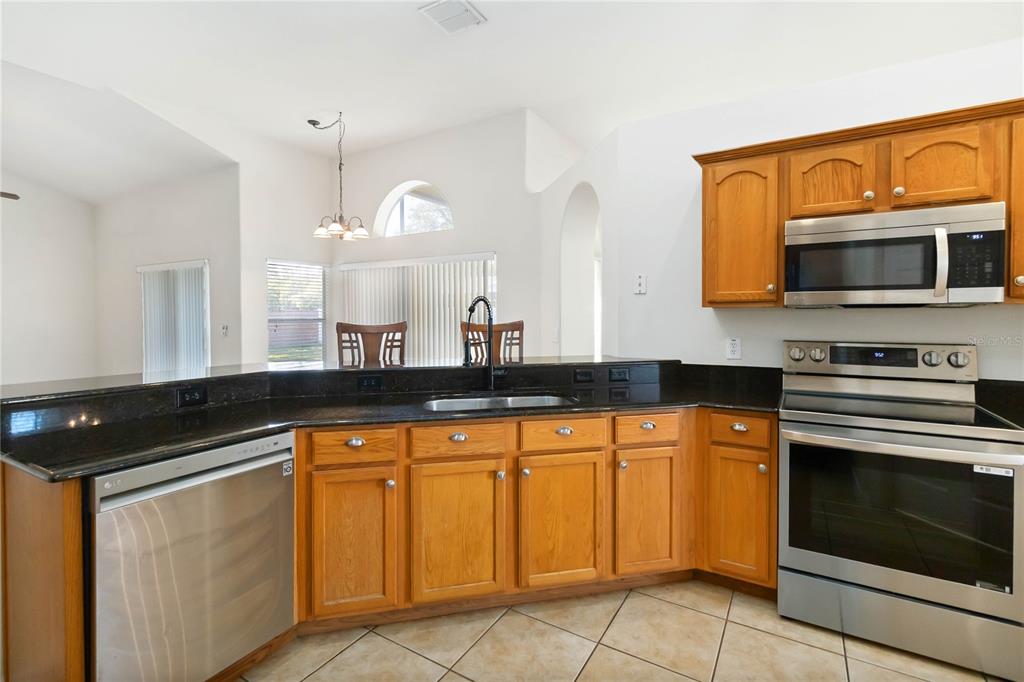 4136 Maidu Court St. Cloud, FL 34772 - Photo 10 of 40 a kitchen with granite countertop a sink and cabinets