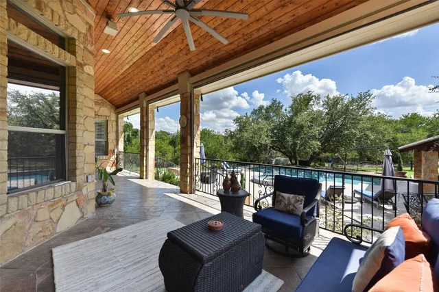 a view of swimming pool with lawn chairs and plants