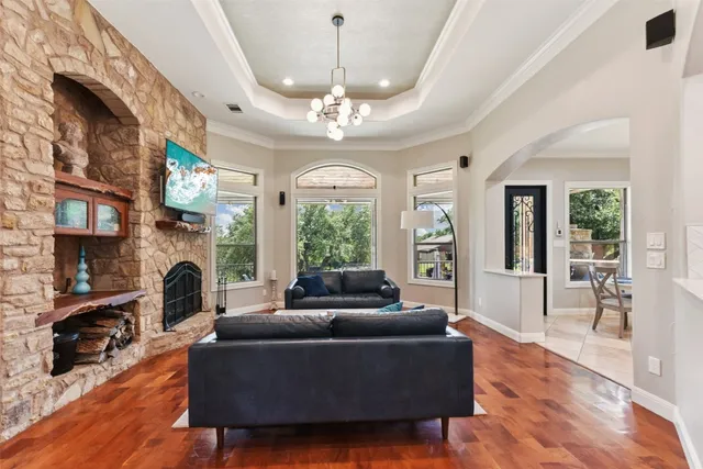 a living room with furniture a chandelier and a fireplace