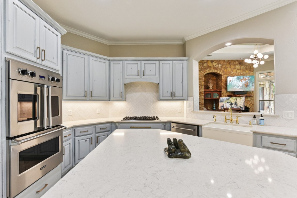 122 Silverstone Drive Georgetown, TX 78633 - Photo 23 of 40 a kitchen with granite countertop a stove sink and cabinets