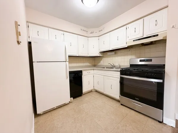 a kitchen with stainless steel appliances white cabinets and a refrigerator