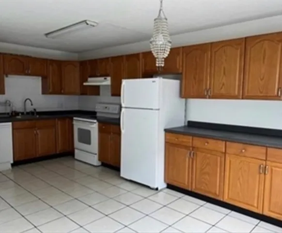 a kitchen with stainless steel appliances granite countertop a stove a sink dishwasher and a refrigerator