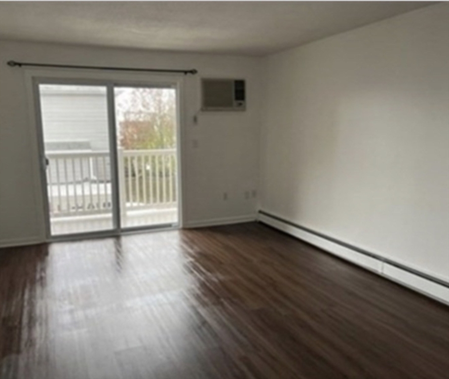 12 Cox Court, Unit 2 Beverly, MA 01915 - Photo 4 of 8 a view of an empty room with wooden floor and a window