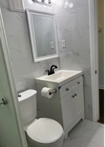 a white toilet sitting next to a bathroom sink