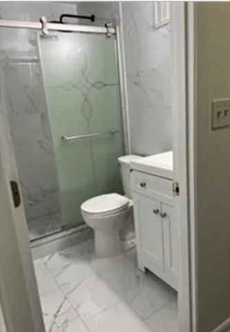 a white toilet sitting next to a shower