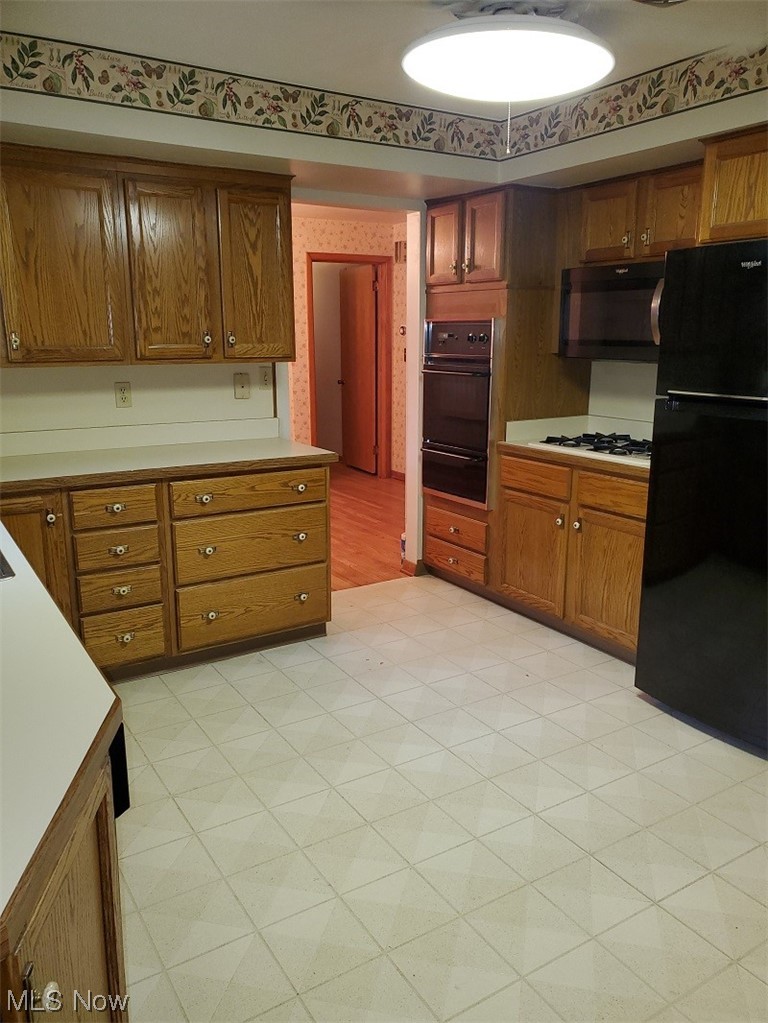 932 Pinecrest Road Girard, OH 44420 - Photo 20 of 25 Kitchen featuring black appliances and light tile floors