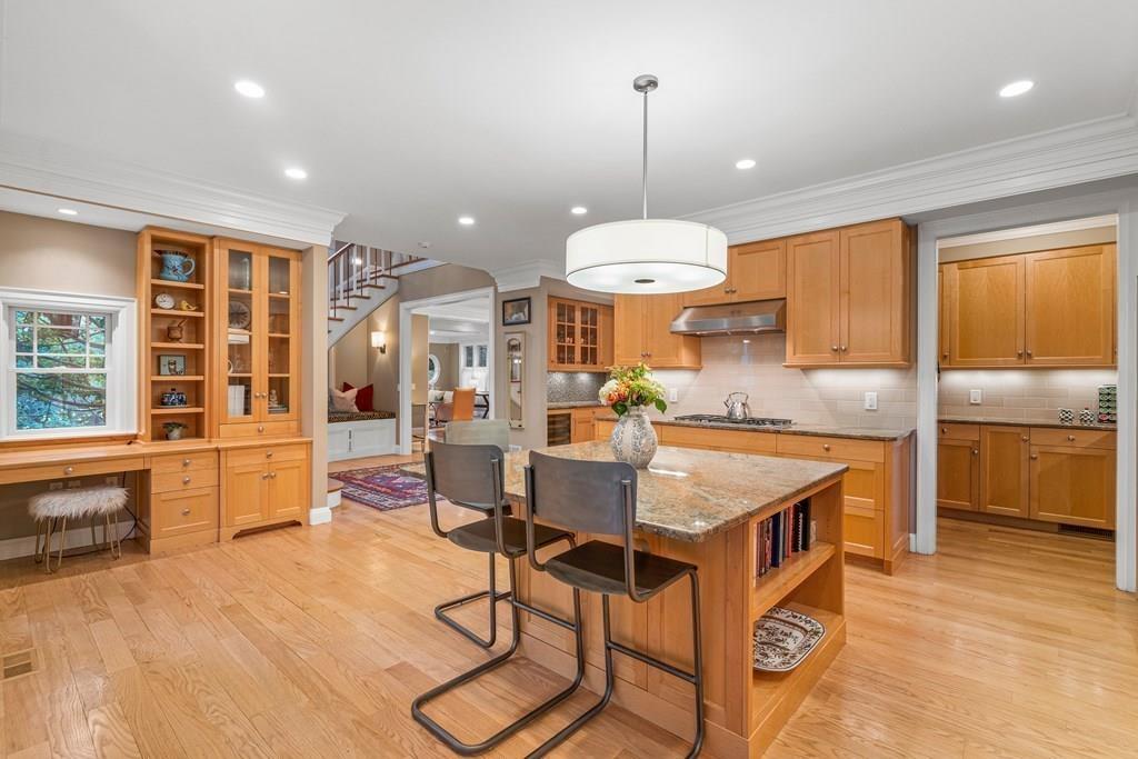 150 Wellesley Street Weston, MA 02493 - Photo 6 of 31 a kitchen with stainless steel appliances kitchen island granite countertop a stove a refrigerator a sink a dining table and chairs with wooden floor