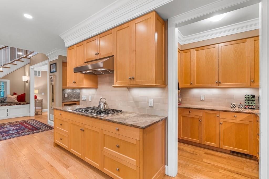 150 Wellesley Street Weston, MA 02493 - Photo 9 of 31 a kitchen with granite countertop wooden cabinets a stove a sink and a window