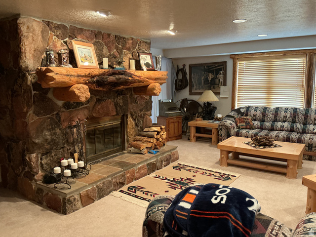 550 State Line Road Manila, UT 84046 - Photo 16 of 41 Floor-to-ceiling stone fireplace featuring a substantial log mantel and a stone hearth