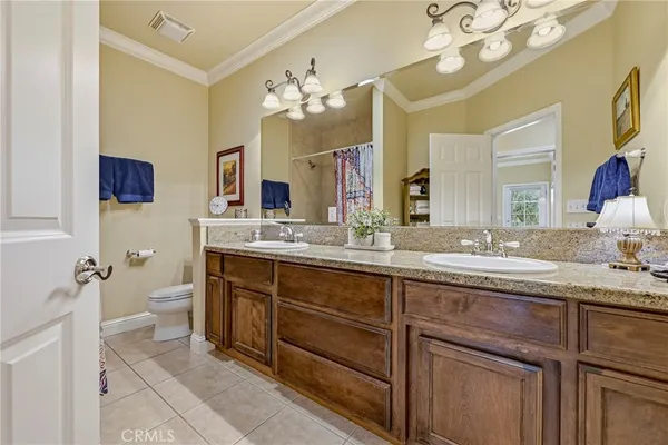 a kitchen with stainless steel appliances granite countertop a refrigerator a sink dishwasher and wooden cabinets with wooden floor