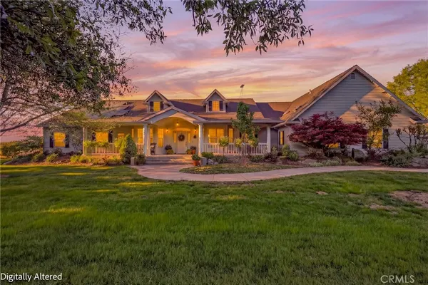 a view of a house with a big yard plants and large trees
