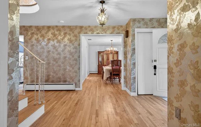 a view of a dining room with furniture a chandelier and wooden floor