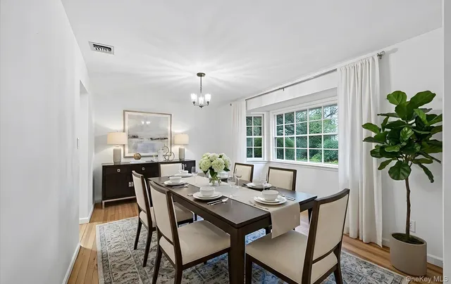 a view of a dining room with furniture a chandelier and wooden floor